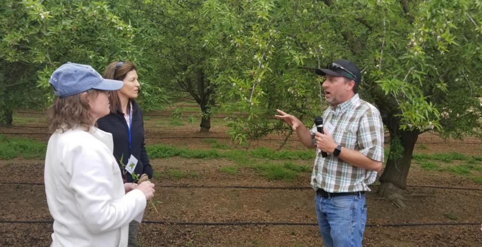 Participants on the Foundation's Central Valley Tour listen to a speaker during a farm stop.