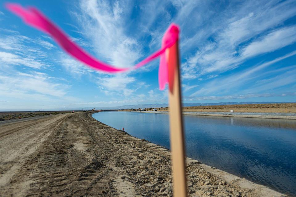 Image shows a survey ribbon fluttering in the breeze during subsidence repair work is underway along the California Aqueduct near Lost Hills in Kern County in 2021. 