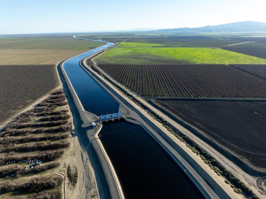 Image shows The California Aqueduct threads its way down the west side of the San Joaquin Valley between orchards and farm fields. 