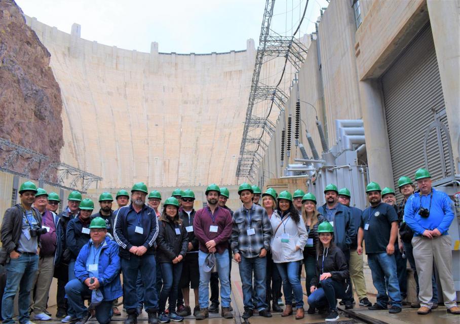 Image shows a Lower Colorado River tour group standing in front of Hoover Dam.