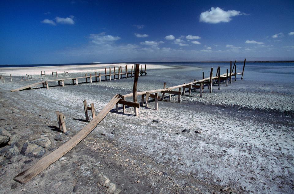 A dock sits stranded at the shoreline of the receding Salton Sea.