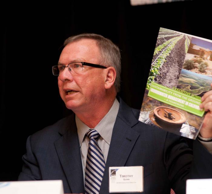 ACWA Executive Director Tim Quinn  with a report produced by Association of California Water Agencies on  sustainable groundwater management.  