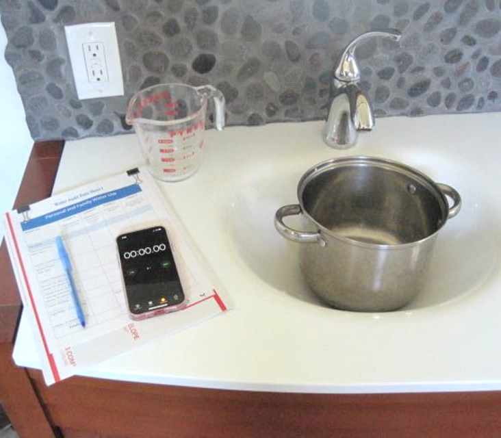 Image of a stockpot beneath a faucet, a measuring cup and tools to document water use for an experiment.