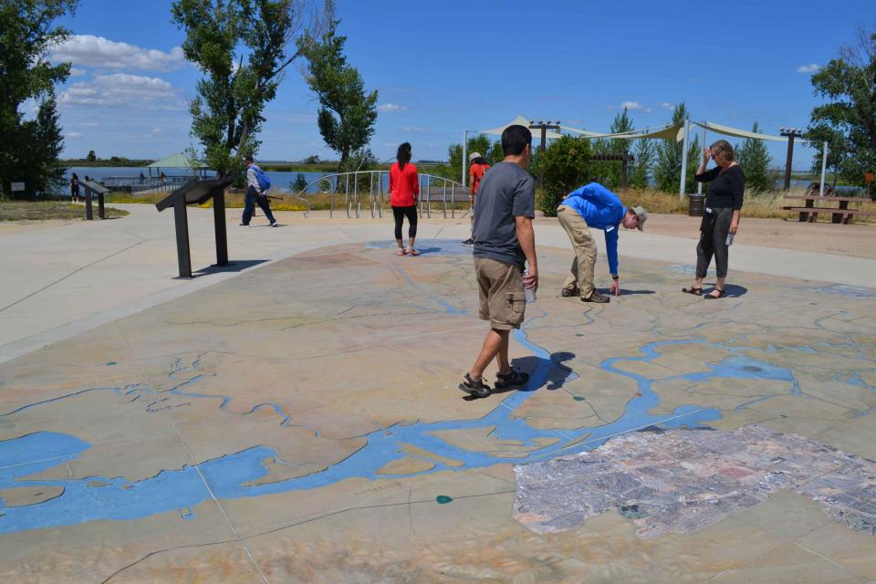 Visitors explore a large, three-dimensional map of the Sacramento-San Joaquin Delta at Big Break Regional Shoreline in Oakley. 