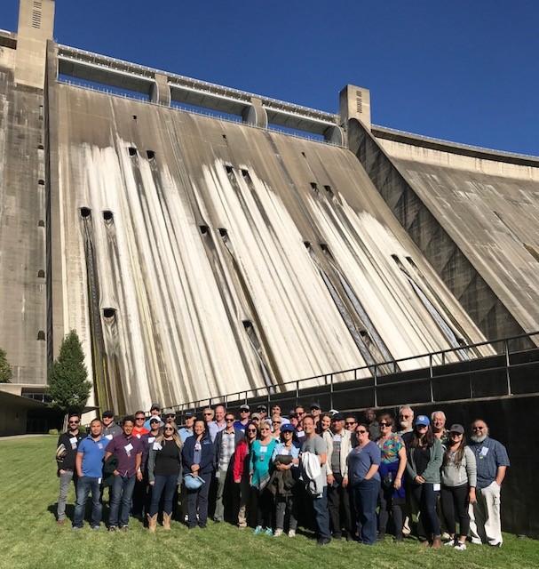 Northern California Tour participants pose in front of an imposing Shasta Dam, one of the highlights on this three-day tour. 