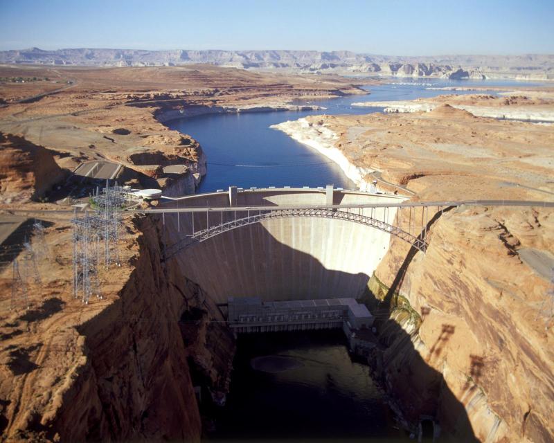 Image shows Glen Canyon Dam with Lake Powell in the background.